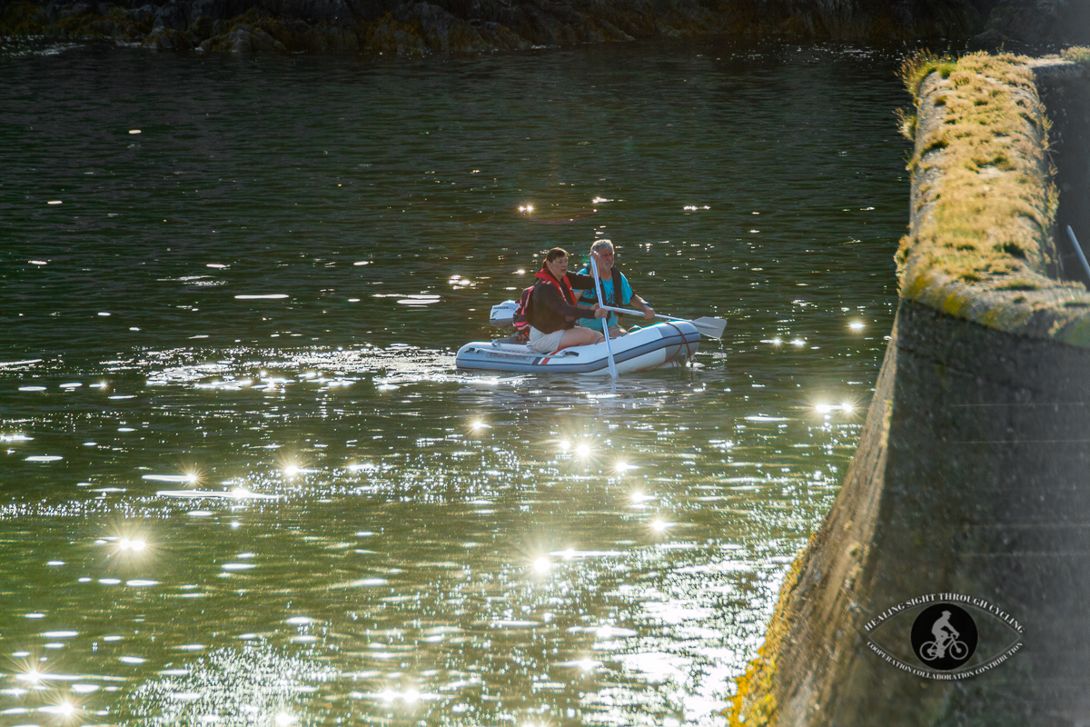 Couple in a dinghy in Glandore Bay sun sparkles on the water - County Cork