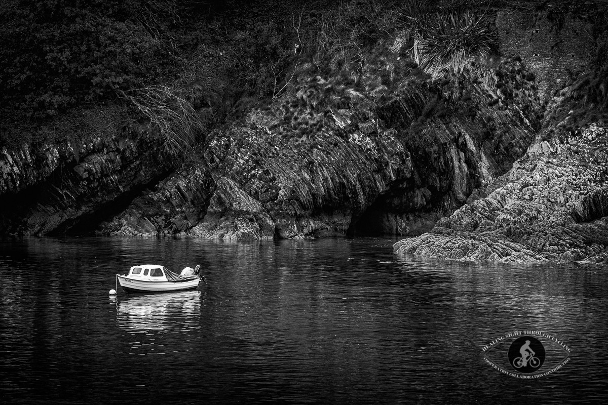 Small fishing boat in rocky cove - Glandore County Cork - BW